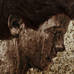 image of a dark haired boy's head in profile, overlaid with flecks of mud
