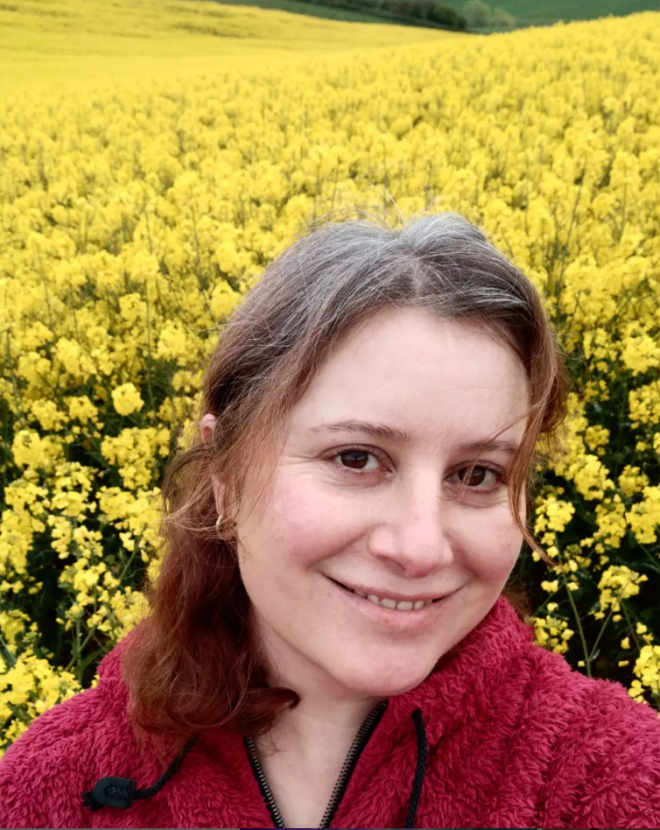 Image of Francoise Harvey against a backdrop of a field of yellow flowering crops (oilseed rape)