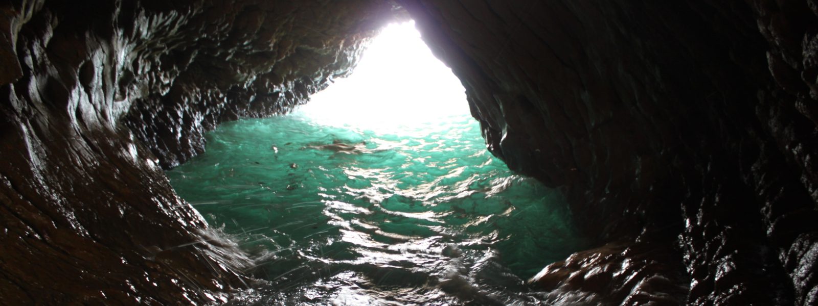 sea cave, dark, with an obscured swimmer
