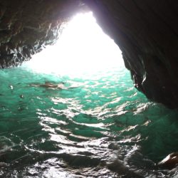 sea cave, dark, with an obscured swimmer