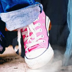 A girl's feet in pink trainers next to the shrouded feet of a grim reaper
