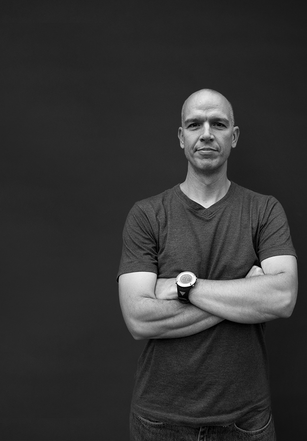 Jonathan Danz in monochrome, his arms folded.